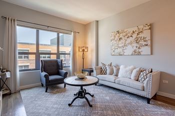 a living room with a couch and a chair and a window
